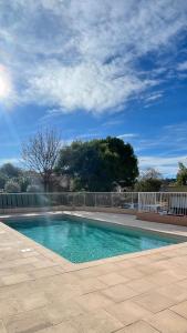 a swimming pool next to a white fence at Appartement 3P Nice in Nice