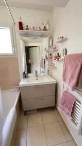 a bathroom with a sink and a tub and a mirror at Appartement 3P Nice in Nice
