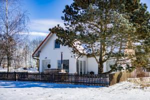 a white house with a fence in the snow at Na Ovčíně in Jindřichŭv Hradec