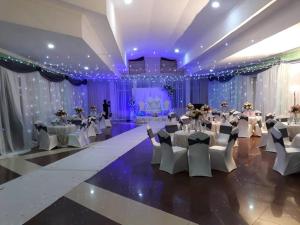a banquet hall with white tables and chairs and purple lighting at Isamilo Grand Hotel in Mwanza +55 photos