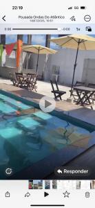 a picture of a swimming pool with chairs and umbrellas at pousada ondas do atlântico in Salinópolis +2 photos