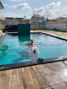 a man in a swimming pool in a yard at pousada ondas do atlântico in Salinópolis
