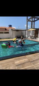 a group of people swimming in a swimming pool at pousada ondas do atlântico in Salinópolis