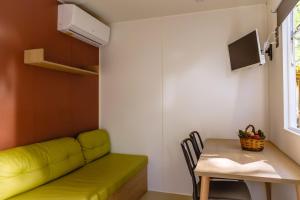a living room with a green couch and a table at Camping Les Pins - Bord de mer in Argelès-sur-Mer