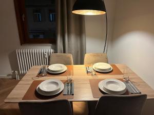 a wooden table with chairs and plates and a lamp at Triberg City Apartment 1 in Triberg