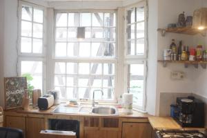eine Küche mit einem Waschbecken und zwei großen Fenstern in der Unterkunft Ferienhaus Bonn in Bonn