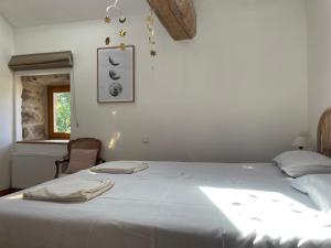 a bedroom with a large white bed and a window at L'ancien Relais de Poste*** in Saint-Dier-dʼAuvergne