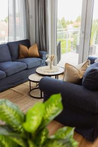 a living room with blue couches and a table at HYGGE HOMES Apartment 'Scandi Sunset' in Winsen