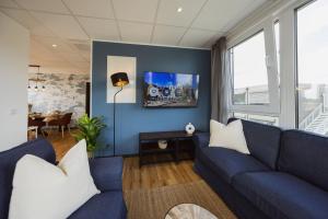 a living room with blue walls and a blue couch at HYGGE HOMES Apartment 'Scandi Sunset' in Winsen