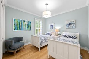 a bedroom with two beds and a chair at Neapolitan Vacation Rentals - Pet Friendly, Newly Updated Luxury Home with Private Pool! Complete Privacy and Only a 10 Minute Walk to Vanderbilt Beach Close to Mercato and the Best of Naples in Naples +29 photos