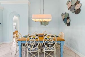 a dining room with a blue table and chairs at Neapolitan Vacation Rentals - Pet Friendly, Newly Updated Luxury Home with Private Pool! Complete Privacy and Only a 10 Minute Walk to Vanderbilt Beach Close to Mercato and the Best of Naples in Naples