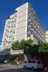Ein weißer Lieferwagen parkte vor einem hohen Gebäude in der Unterkunft Hotel Essencia in Dumaguete