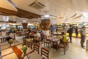 Eine Gruppe von Menschen sitzt an Tischen in einem Restaurant in der Unterkunft Hotel Essencia in Dumaguete