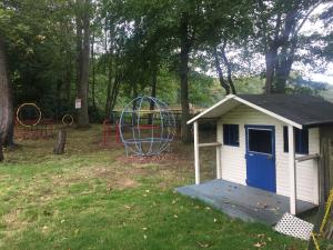 ein kleiner Schuppen mit einer blauen Tür neben einem Spielplatz in der Unterkunft The Winchfield Inn in Winchfield