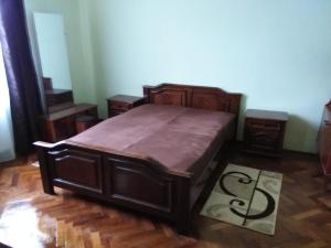 - une chambre avec un grand lit en bois et du parquet dans l'établissement Apartament NORA, à Braşov