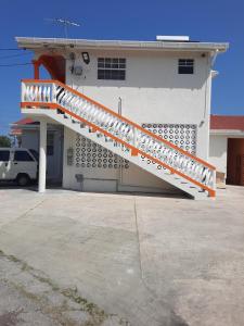 a white building with an orange and white staircase at Joyville in Bridgetown +3 photos