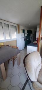 a kitchen with a table and a chair and refrigerator at Colocation Du Grand Large in Décines-Charpieu