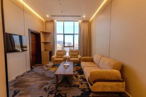 ein Wohnzimmer mit Sofa, Stühlen und einem Tisch in der Unterkunft Grand hotel alhamra in Dschidda