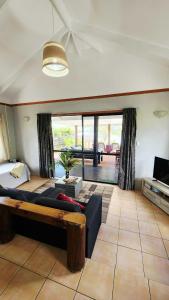 a living room with a bed and a couch at Sunset Palms Rarotonga in Rarotonga +85 photos
