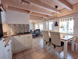 a kitchen and living room with a table and chairs at Hygge in Wrixum