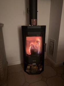 a black stove with a fire in a room at Hygge in Wrixum