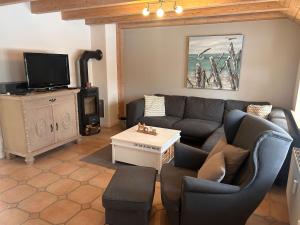 a living room with a couch and a tv at Hygge in Wrixum