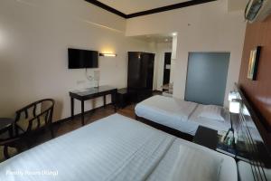ein Hotelzimmer mit zwei Betten und einem Schreibtisch in der Unterkunft Hotel Essencia in Dumaguete