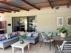 a patio with a blue couch and a table at Lilibeth guesthouse in Parys