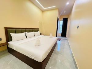 a bedroom with a large bed with white pillows at SR Resort in Milkīpur +15 photos