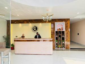 a man sitting at a bar in a lobby at SR Resort in Milkīpur