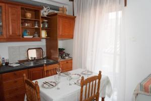 una cocina con una mesa con copas de vino. en Meteora Christian's Place, en Tríkala