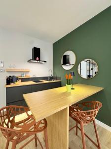 a kitchen with a wooden table and two chairs at Valcamonica Apartments - Lake in Boario Terme