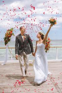 a bride and groom walking on a pier with confetti at Canonnier Beachcomber Golf Resort & Spa in Pointe aux Canonniers +76 photos