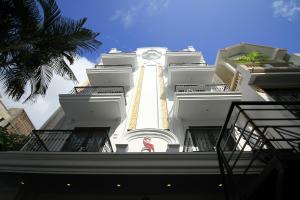 Un grand bâtiment blanc avec une horloge. dans l'établissement The Scarlett Boutique Hotel, à Hue