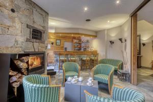 a living room with chairs and a fireplace at Brit Hotel Florimont in Saint-Ferréol