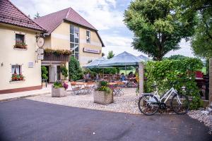a bike parked in front of a building with a patio at Landgasthof Freiberger in Schnabelwaid