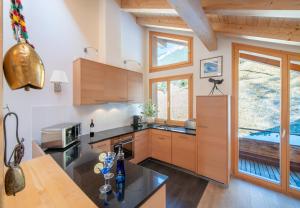 a kitchen with wooden cabinets and a large window at Chalet Stella Penthouse Residence in Wengen