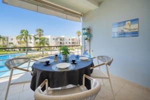 a dining room with a table and chairs and a pool at Vila da Praia by ALgest in Alvor