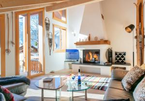 a living room with a couch and a fireplace at Chalet Stella Penthouse Residence in Wengen