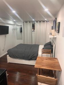 a bedroom with a bed and a wooden table at Cute and Cozy Studio with Private Parking in Montreal