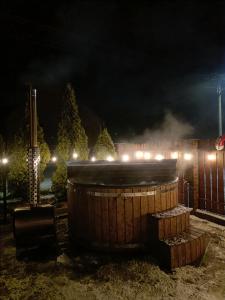 a hot tub with smoke coming out of it at night at Agroturystyka Rewita in Darłowo +4 photos