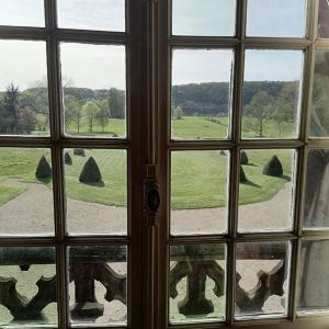 a window looking out at a view of a golf course at Manoir de Villers in Saint-Pierre-de-Manneville