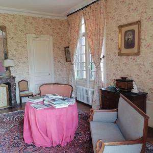 a living room with a pink table and chairs at Manoir de Villers in Saint-Pierre-de-Manneville