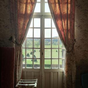 a window with a view of a field of grass at Manoir de Villers in Saint-Pierre-de-Manneville