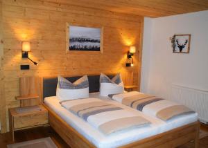 a bedroom with a large bed with two pillows at Pension Zum Lebzelter in Freyung +6 photos