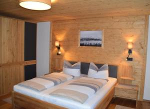 a large bed in a room with a wooden wall at Pension Zum Lebzelter in Freyung