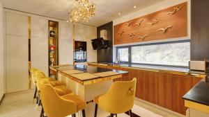 a kitchen with yellow chairs and a table and a window at Relax in Style Boutique Hotel in Braşov