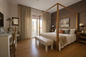 a bedroom with a canopy bed with a white bedspread at Maxim in Palermo +15 photos