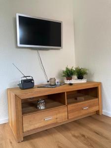 a wooden entertainment center with a flat screen tv on a wall at Ferienhaus Helmshuus in Leer