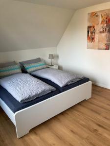 a bedroom with a bed and a painting on the wall at Ferienhaus Helmshuus in Leer
